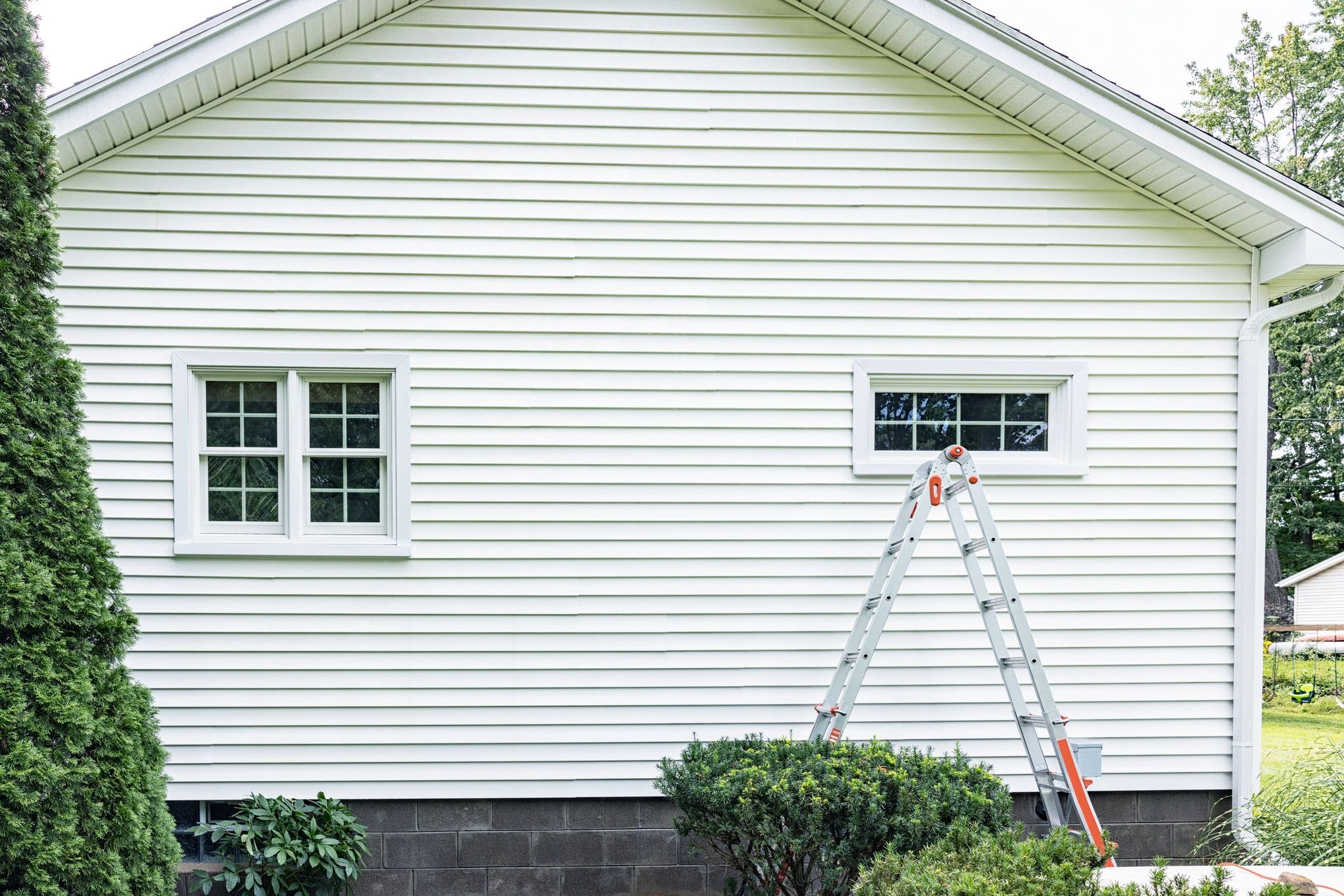 White house exterior window cleaning with ladder in Land O' Lakes FL